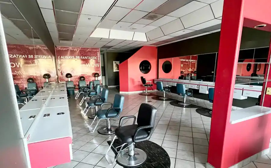 Main salon floor with styling stations, dryer chairs, and mirrors